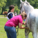 A Pony Club member with her horse waiting while a vet checks the heart rate of the horse after a Cross Country round.