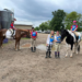 Mounted and unmounted riders standing in front of the camera, smiling