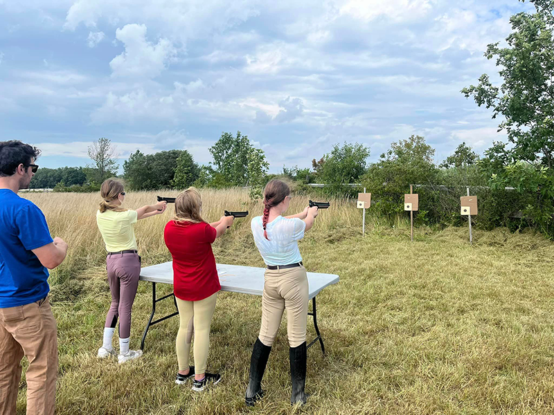 Three riders shooting as part of Tetrathlon.