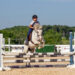 A girl jumping her horse towards the camera.