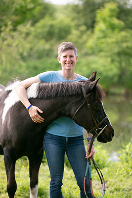 A woman and her horse, smiling for the camera.