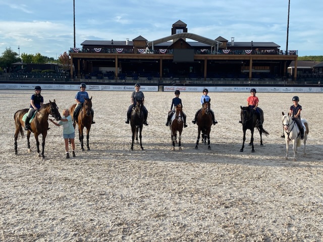 A group of kids on horseback, standing together for the camera.