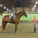 A young girl on her horse talking to an instructor.