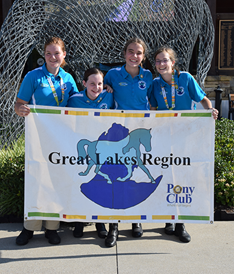 A group of girls holding a banner at USPC Championships East 2022.