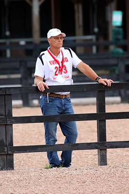 A man standing at a fence.