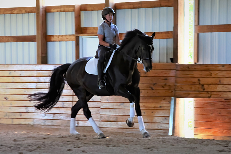 A woman riding her horse.