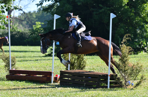 A girl jumping Cross-Country with her horse.