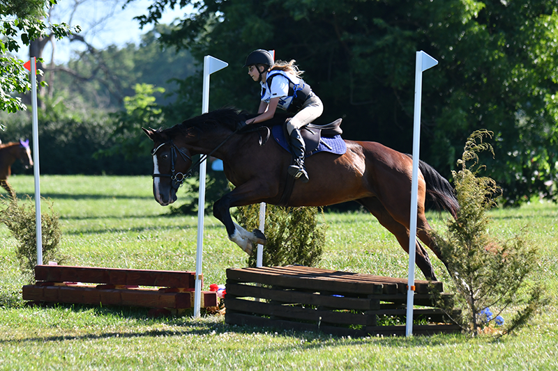 A girl jumping Cross-Country with her horse.