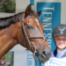 A young girl and her horse, smiling at the camera.