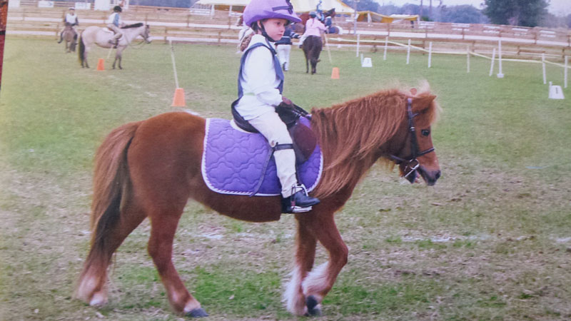 young girl riding fuzzy shetland pony