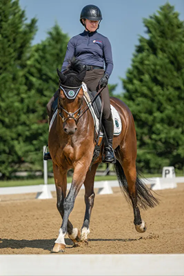 A woman riding her horse dressage.