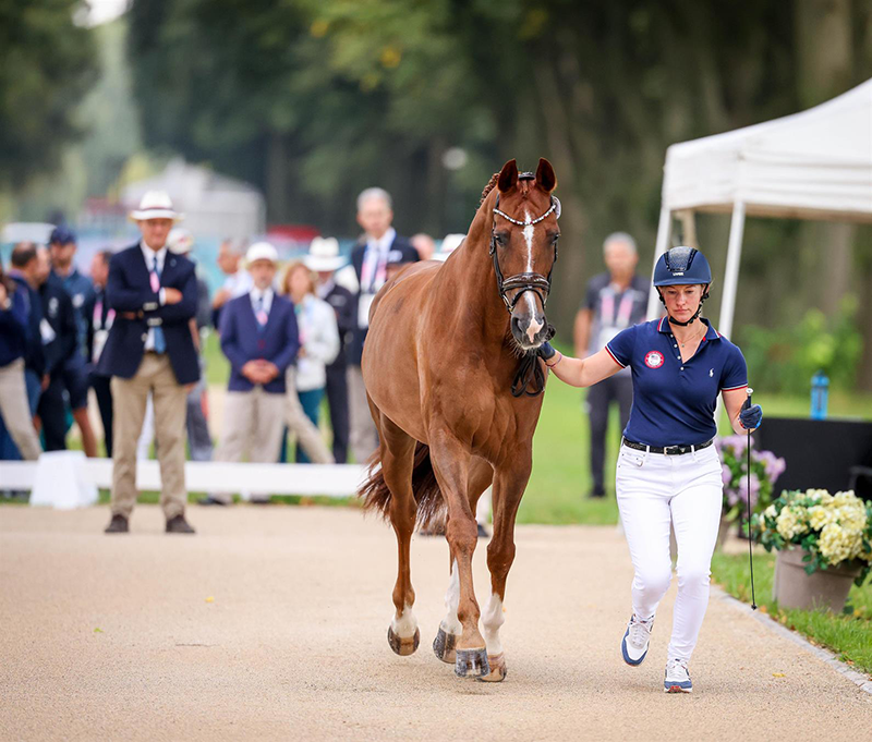 A woman jogging her horse for inspection at the 2024 Paralympic Games.