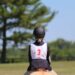 young girl wearing safe horseback riding helmet