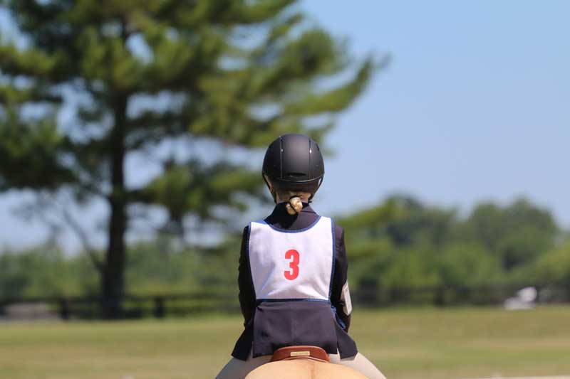 young girl wearing safe horseback riding helmet