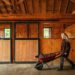 spring horse care with woman pushing wheelbarrow down barn aisle