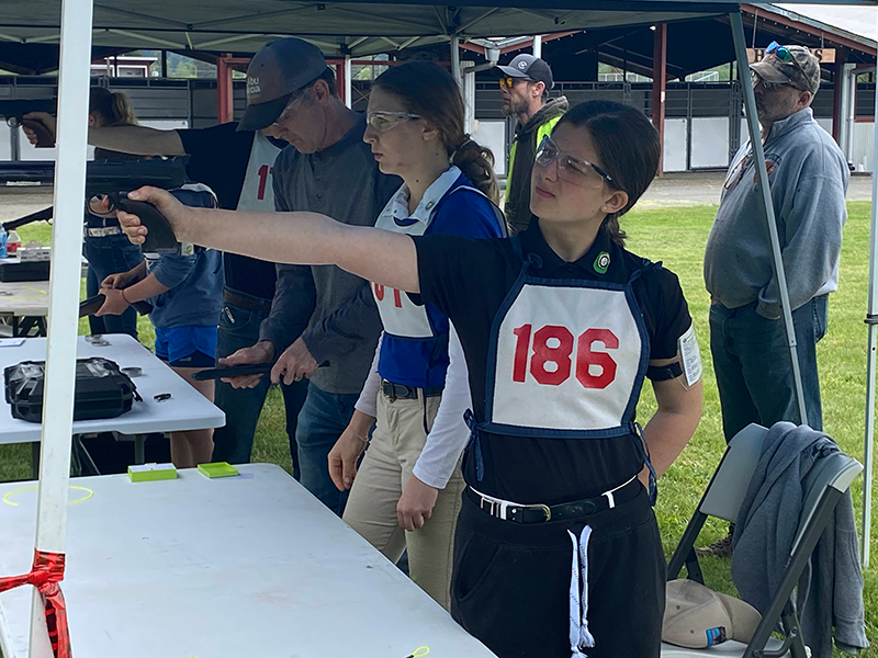 A young girl aiming a Tetrathlon air rifle.
