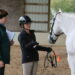 A young woman explaining to an older woman about her horse.