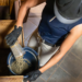 A person pouring horse feed into a bucket.