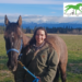 A young woman with her horse, smiling at the camera.